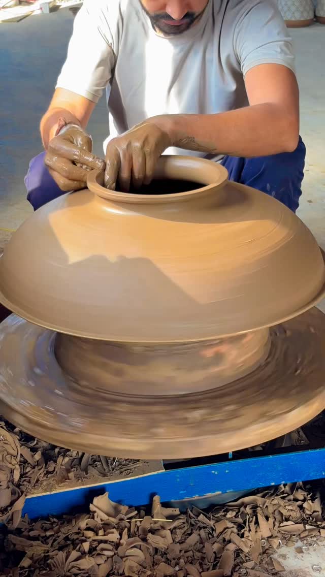 Ishver shaping a large Chandani grain pot on a potter’s wheel.