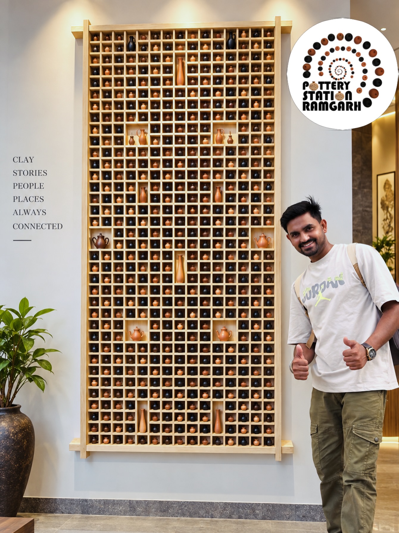 A tall display of handmade miniature pottery in black and terracotta.